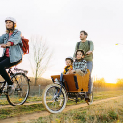 Personne roulant sur un vélo cargo avec ses 2 enfants